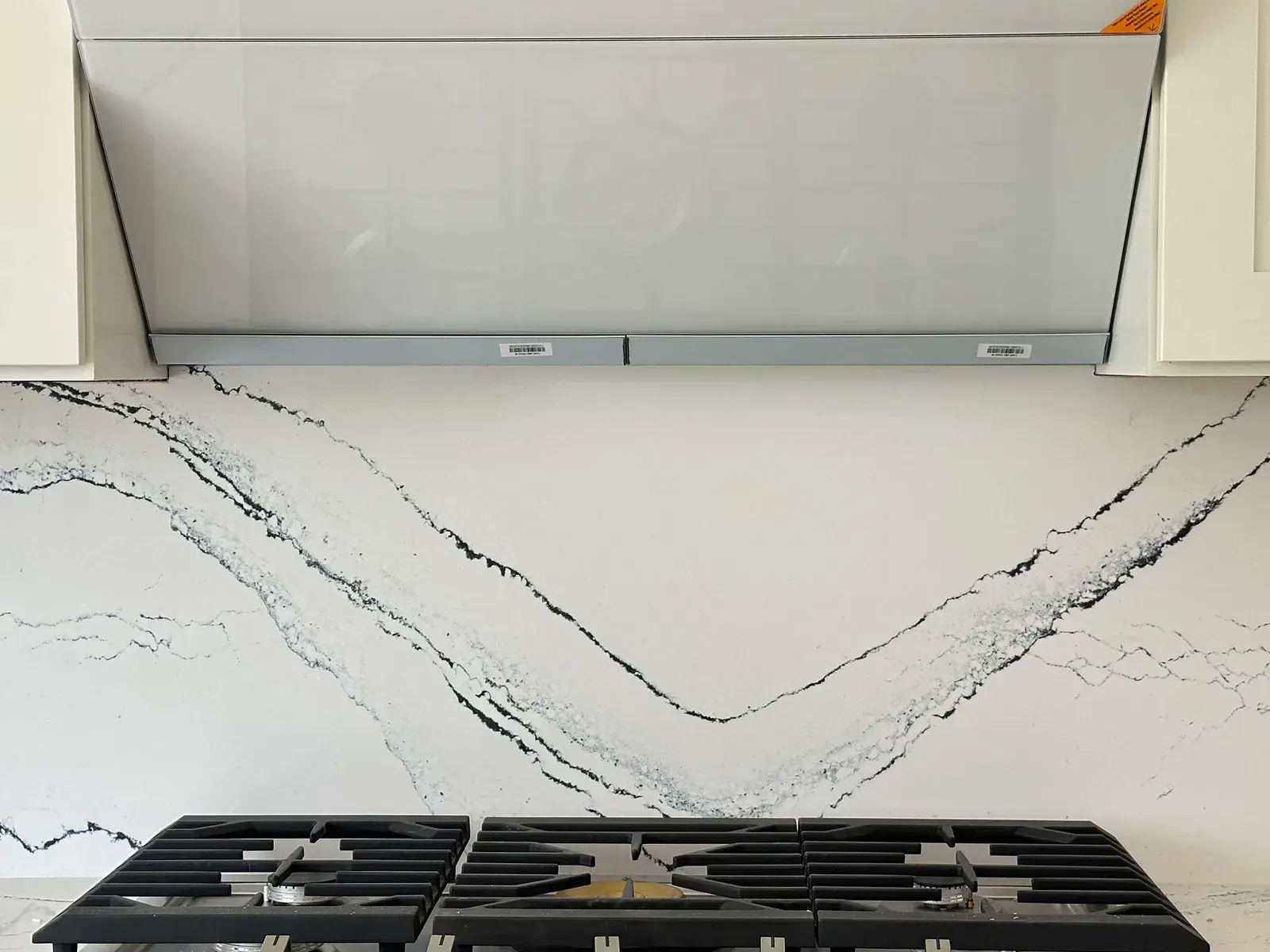 Finished Redmond kitchen detail with a quartz backsplash and a professional gas range